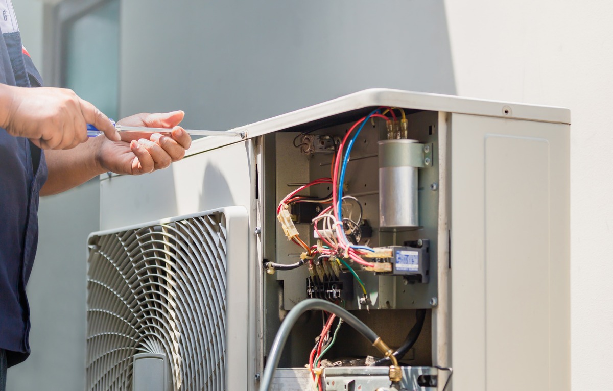 AIM technician servicing an air-conditioning condenser unit