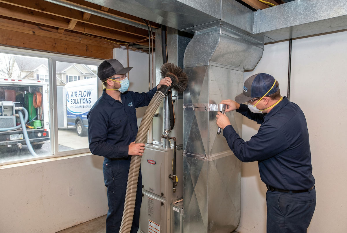 Technicians cleaning residential ductwork